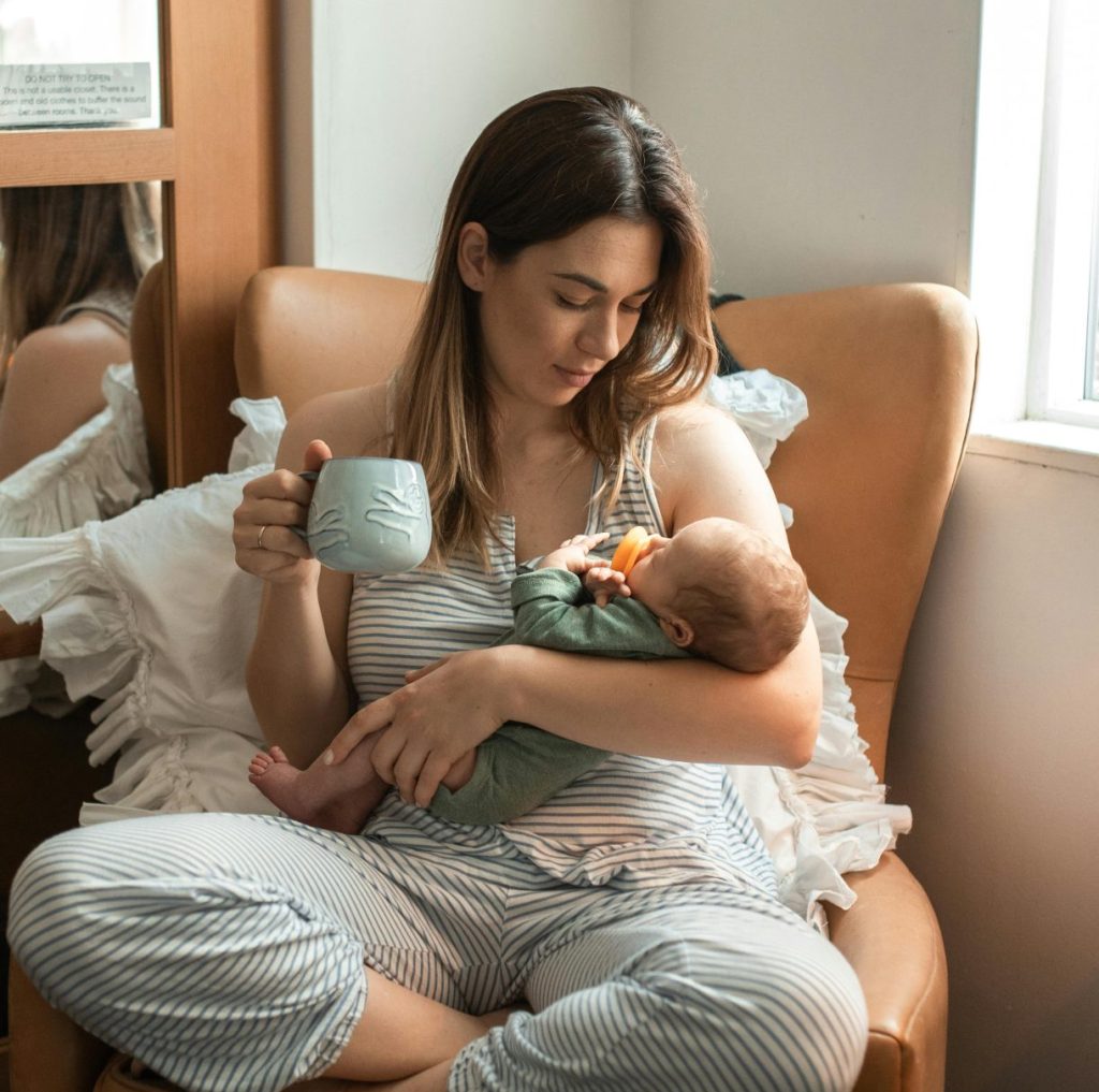 Mother cradling newborn in a cozy indoor setup. Perfect family and lifestyle theme.